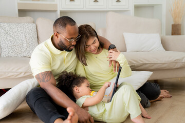 Obraz premium Happy Family Of Three With Little Daughter Having Fun Together At Home, Playing With Their Child In the Living Room, Happy black family Weekend.