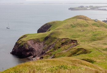vue sur le bord de la mer à partir du haut de la falaise de pierre avec du gazon vert au sol en été