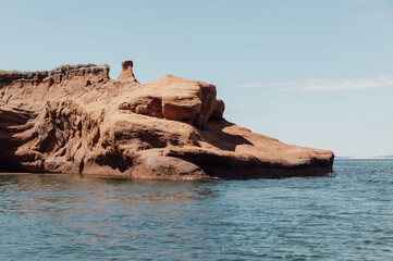 vue sur un rocher rouge en bord de l'eau en été avec une eau calme dans la mer