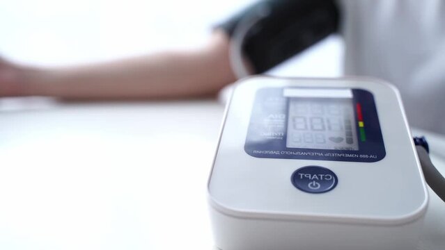 the girl measures blood pressure with a tonometer