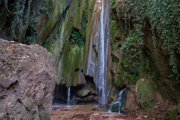 Obraz premium Waterfall in the autumn forest. Autumn forest waterfall. Autumn waterfall in autumn forest. Waterfall landscape. High quality photo