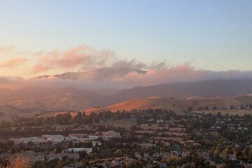 Fototapeta na wymiar Marine layer low clouds moving over the slopes of Mt Diablo in the East Bay at sunset