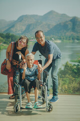 happy asian family with grandmother sitting on wheel chair