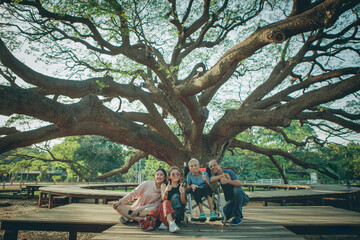happiness asian family sitting under big raintree