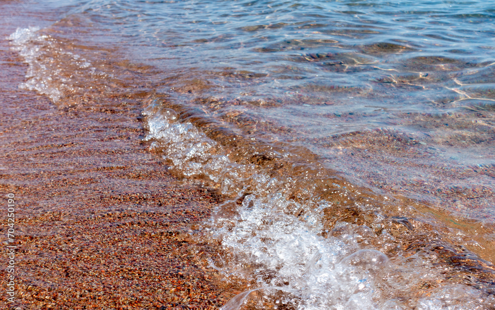 Wall mural Clean transparent water, wave on the sand. Coastline. Kyrgyzstan, Lake Issyk-Kul. natural background.