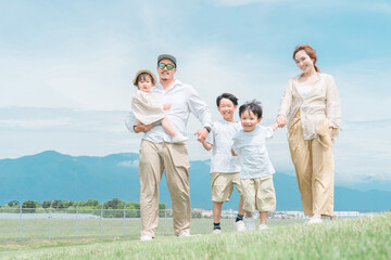 家族旅行・春・夏に青空の見える公園で遊ぶ家族・ファミリー・親子
