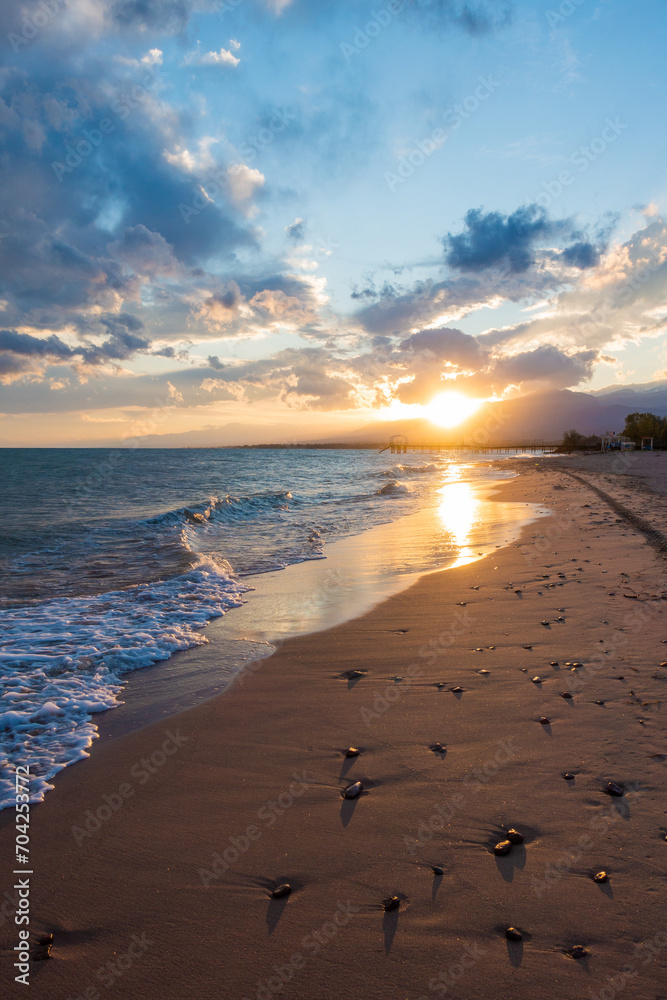 Wall mural colorful sunset on the sea. mountain lake in the rays of the orange sun. kyrgyzstan, lake issyk-kul.