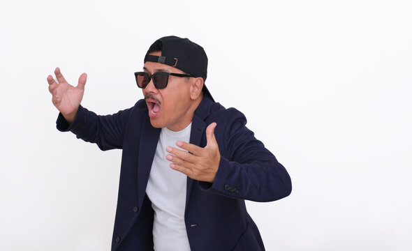 A man wearing a dark blazer over a white t .-shirt, backwards hat and sunglasses shouted angrily