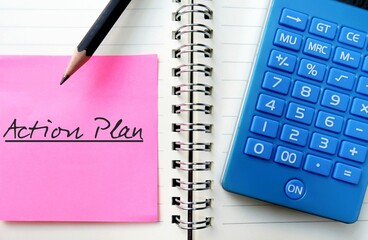 Pink paper note on notebook with pencil writing ACTION PLAN, to write proposed strategy or course of action,  lists what steps must be taken in order to achieve specific goal