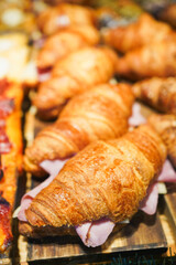 Ham-filled croissants on a wooden board.