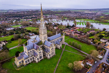 Aerial drone shot of Salisbury Cathedral with flooded fields in background as River Avon bursts...