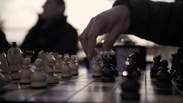 Playing chess on the street. Player moves the black pieces.