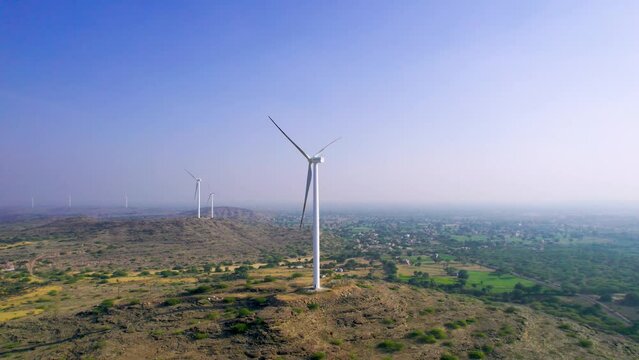 Aerial drone shot orbiting around windmill wind turbine generators in Jaisalmer Rajasthan Gujarat showing alternate renewable energy sources in thar desert and aravalli range