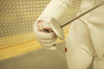 Professional fencer girl with fencing mask and rapier. Training in hall	