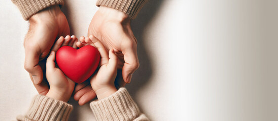 Adult and child hands holding red heart, family insurance, organ donation, love