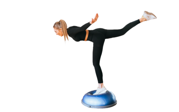 Young caucasian woman in black sportswear balancing on one leg using hemisphere against transparent background. Fit Italian girl at workout  in balance pose. Sport club, healthy lifestyle.