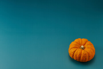 小型のカボチャを中心に右下に1個配置した青色系背景あり俯瞰撮影