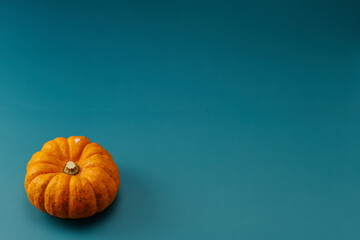 小型のカボチャを中心に左下に1個配置した青色系背景あり俯瞰撮影