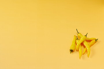黄色系唐辛子を複数右下に複数配置した黄色系背景あり俯瞰撮影