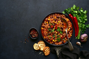 Chili con carne - traditional mexican minced meat and vegetables stew in tomato sauce in a cast...
