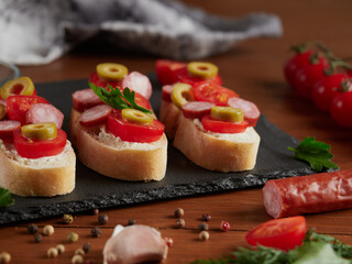 Fototapeta na wymiar Bruschetta with tomatoes, mozzarella cheese and basil on a cutting board. Traditional italian appetizer or snack, antipasto. Top view with copy space. 