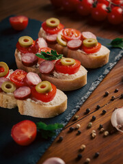 Bruschetta with tomatoes, mozzarella cheese and basil on a cutting board. Traditional italian appetizer or snack, antipasto. Top view with copy space. 