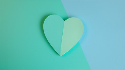 Paper heart on a split green and blue background. Copy space for text. Love, Valentine's Day, Wedding concept. For banner, greeting card, invitation, postcard, poster