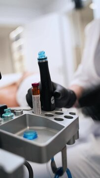 Beautician attaches nozzle to hydrafacial machine for clients skin rejuvenation treatment. Expert prepares equipment for hydro dermabrasion procedure, non-invasive exfoliation in clinic.