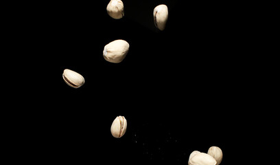 Falling pistachio nuts isolated on black