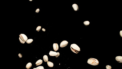 Falling pistachio nuts isolated on black