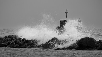 Stone pier withstands strong winds and high waves of the Markermeer. The wind makes the high waves...