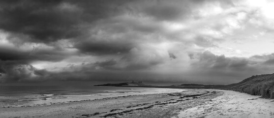 Beautiful dramatic  black and white unusual Winter landscape of snow on Embleton Bay beach in Northumberland England - 704301956