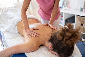 Obraz na płótnie Canvas Professional massage therapist treating back of client