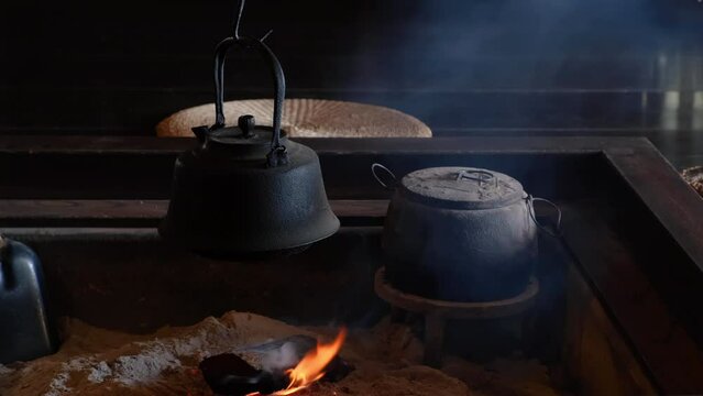 An old vintage smoked kettle is boiling water in the old kitchen.
