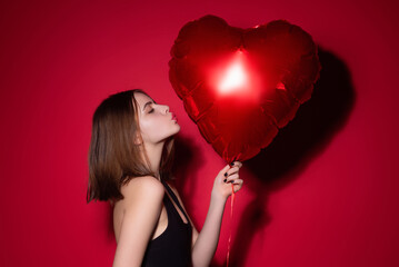 Valentines day. Beauty valentine woman. Studio portrait of valentine model with red valentine heart balloon. Valentines woman, Valentines gift. Valentine design. Valentines day card with sexy woman.