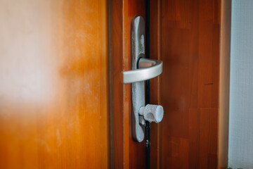 close-up of a frosted door handle with a wooden door, suggesting cold temperature or indoor condensation