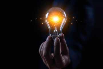businessman holding a light bulb Creativity and imagination, ideas, knowledge, and design...