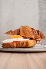 Croissant with fried egg and pastrami on a gray plate