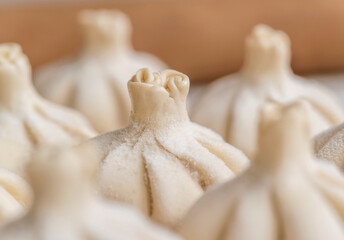 Raw frozen khinkali  on wooden table. Process preparation georgian meal. food concept.