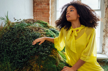 Fashion and beauty shooting a charming mixed race girl in a long yellow dress
