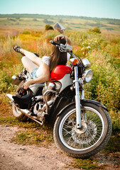 Young biker woman on the country road