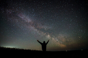 a man on the background of the starry sky with the Milky Way