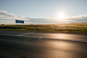 a sign near the road at sunset