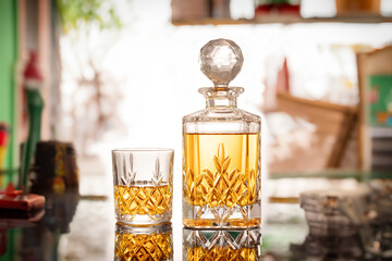 Decanter and cognac or crystal crockery, glassware on nackground of traditional mexican interior