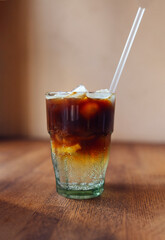 Coffee tonic with piece of orange and ice in glass