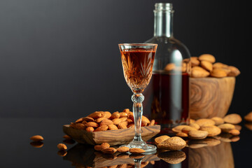 Italian liqueur Amaretto with almonds nuts on a black background.