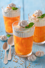 Delicious and creamy orange jelly served with meringue and cream.