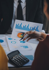Financial analysts analyze business financial reports on a digital tablet planning investment project during a discussion at a meeting of corporate showing the results of their successful teamwork.