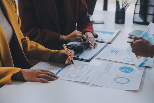 Financial Analysts Analyze Business Financial Reports On A Digital Tablet Planning Investment Project During A Discussion At A Meeting Of Corporate Showing The Results Of Their Successful Teamwork.