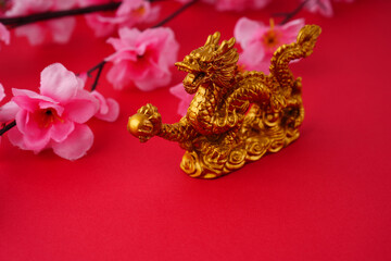 Golden dragon on red background with Pink Flower on the side. 